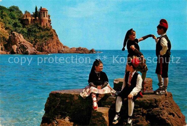Blanes Kinder in Tracht auf Felsen am Meer