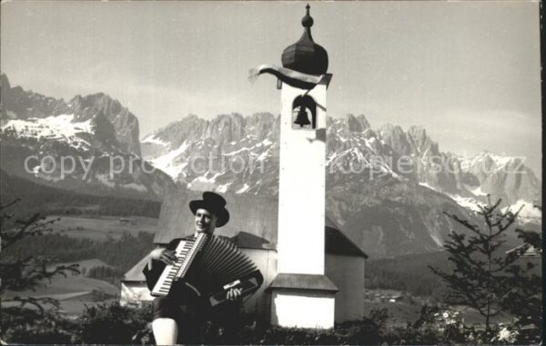 Ellmau Tirol Mann mit Akkordeon an Kirche